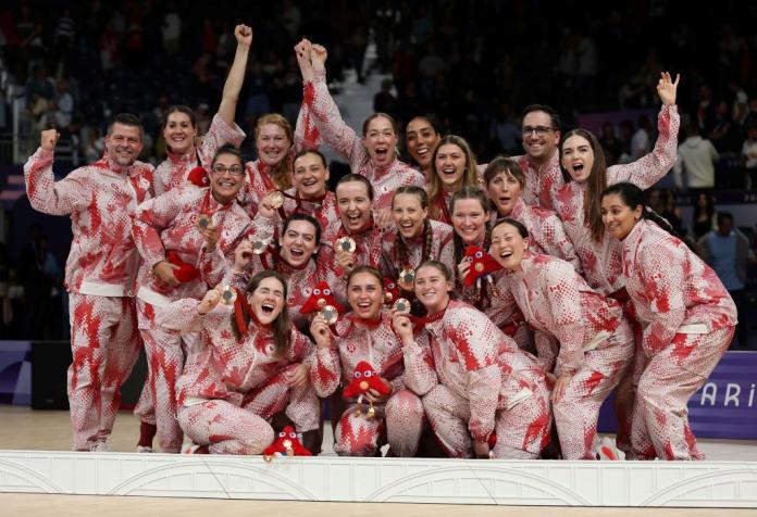 Canada's women's sitting volleyball team pose for a photo on the podium after receiving bronze medals