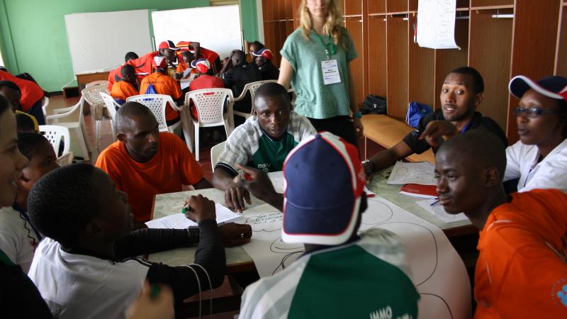 Athletes discuss their dreams in a workshop at the Agitos Foundation Youth Workshop in Rwanda athletes sitting around a table in discussion