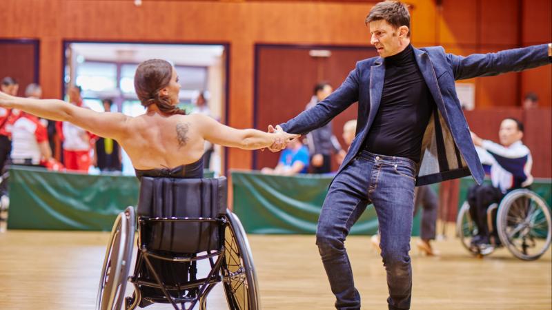 Woman wheelchair dancer and her standing partner perform