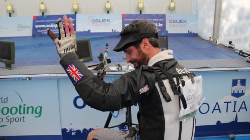 Great Britain's James Bevis - shooting Man raises arm after shooting a rifle