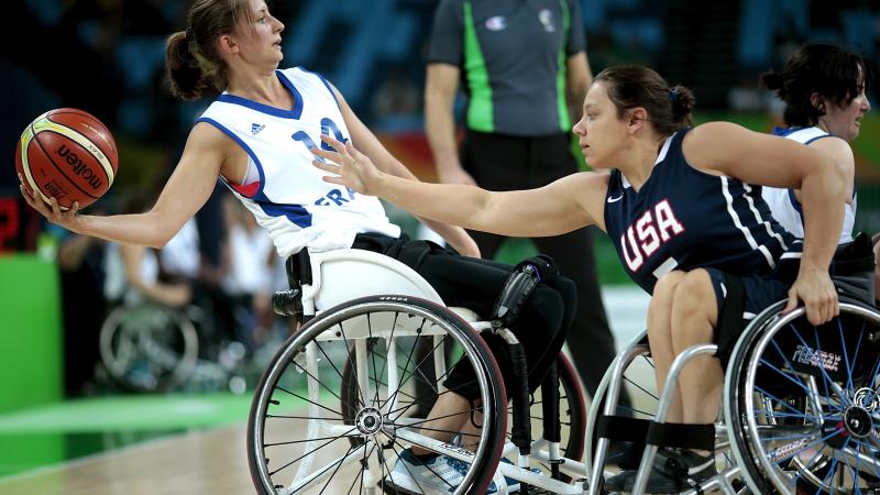Marianne Buso - France - wheelchair basketball Woman in wheelchair holding a basketball while another tries to defend her