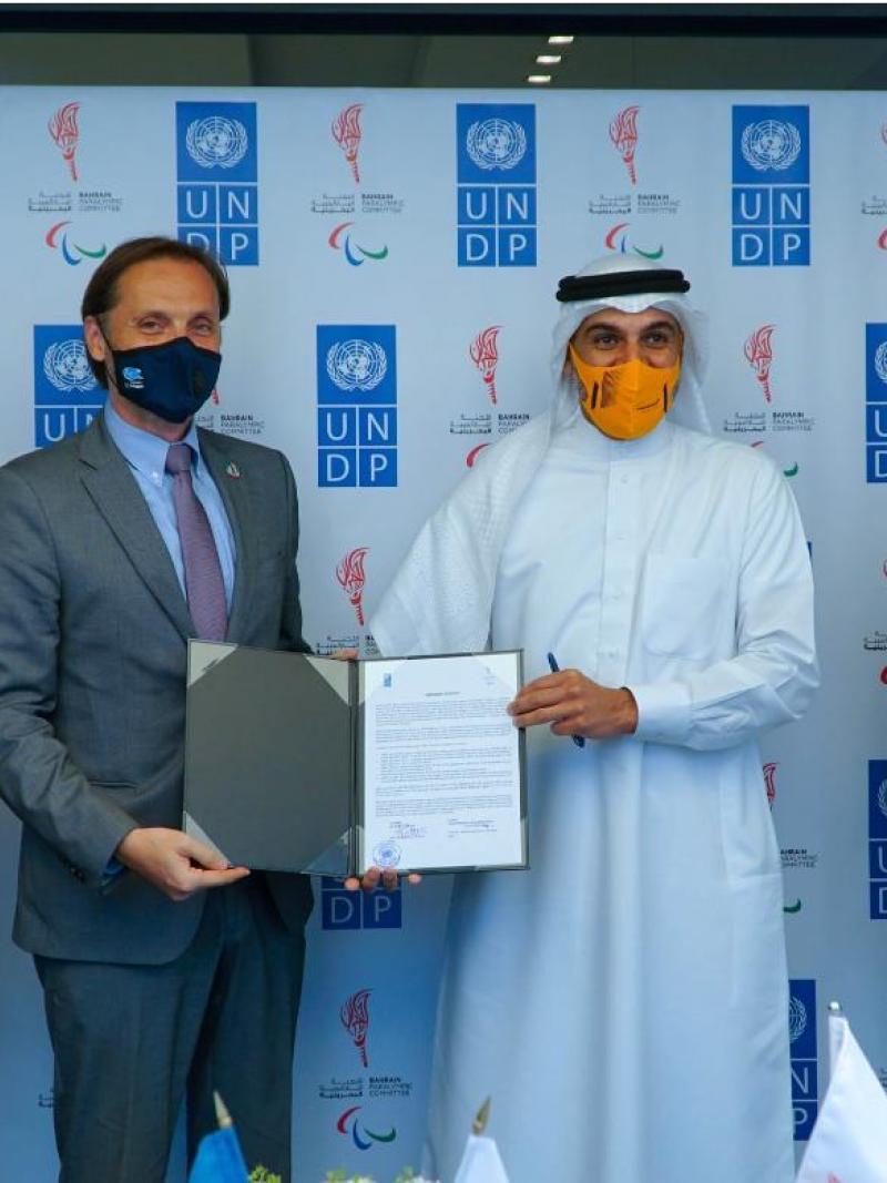Group of men posing for photo holding signed agreement